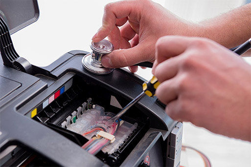 تعمیرکار در حال تعمیر یک پرینتر رنگی معیوب_ عکس استفاده شده در سایت aloocartridge.com